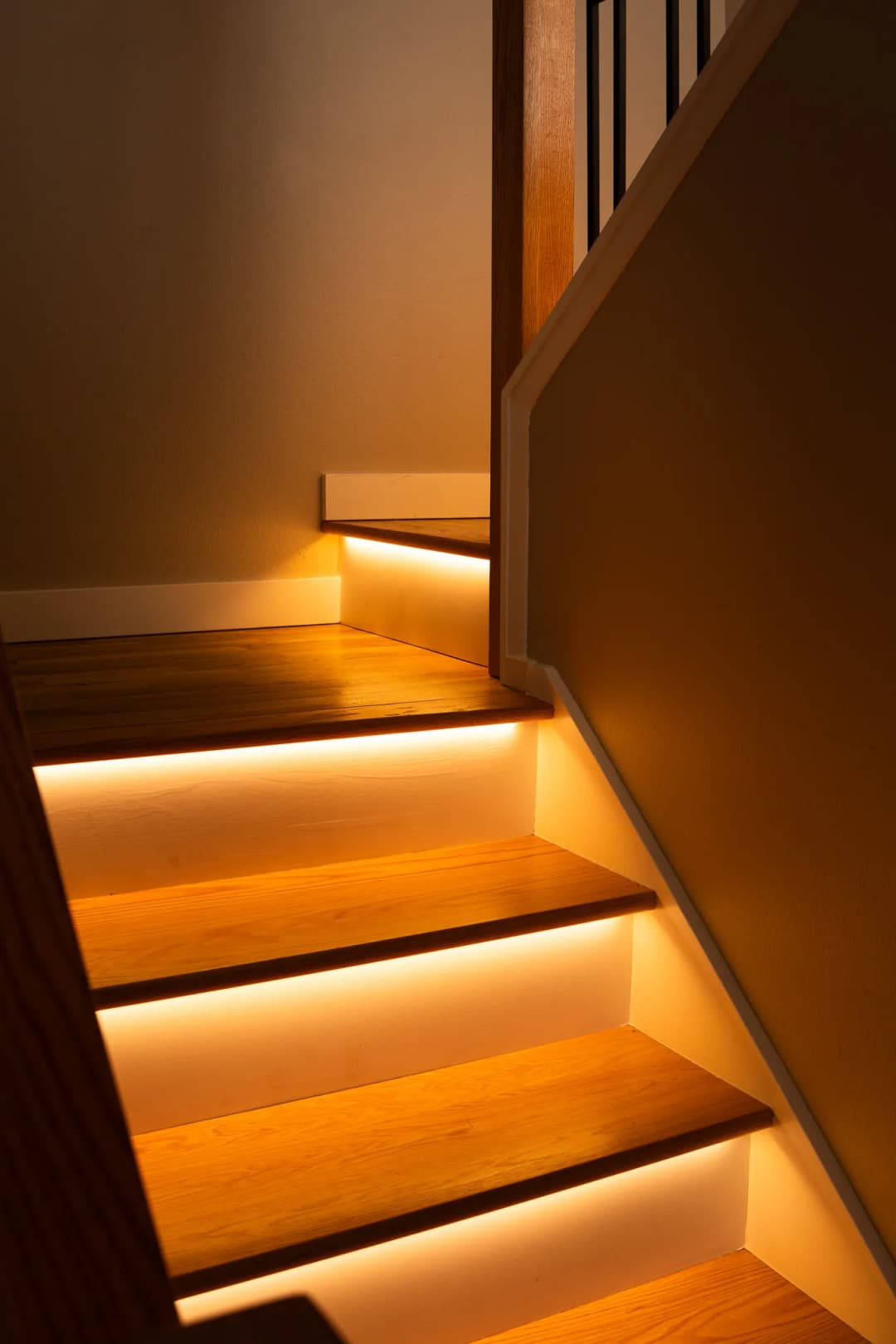 Illuminated wooden staircase with warm LED lights enhancing its elegant design.