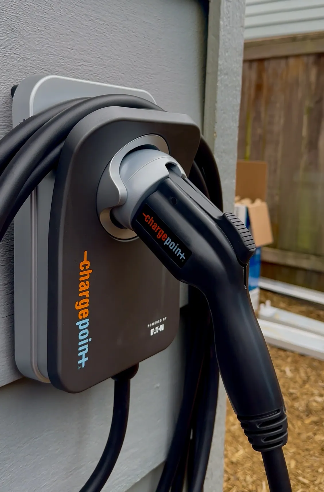 Electric vehicle charging station with ChargePoint plug attached to a wall.